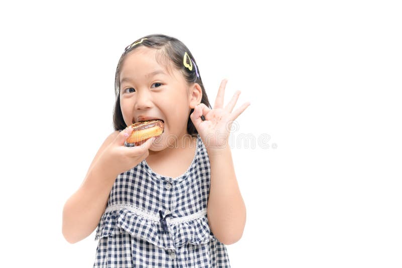 Little happy cute girl is eating donut isolated stock photo Little happy cute girl is eating donut isolated stock photo