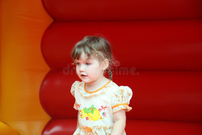 Little happy girl jumps on bouncy castle