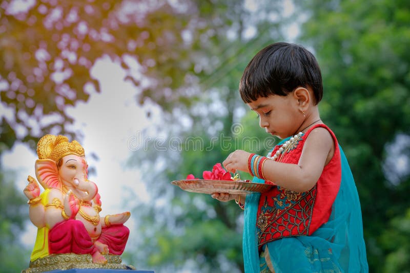 Little Indian girl child with lord ganesha and praying , Indian ganesh festival stock photo Little Indian girl child with lord ganesha and praying , Indian ganesh festival stock photo