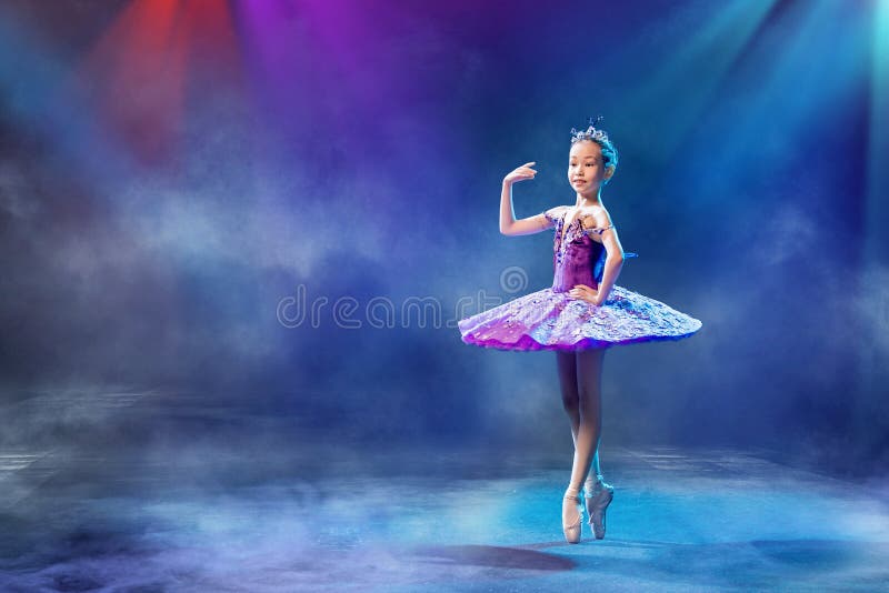 A Little Japanese Ballerina Dances on Stage in a Lilac Tutu on Pointe ...