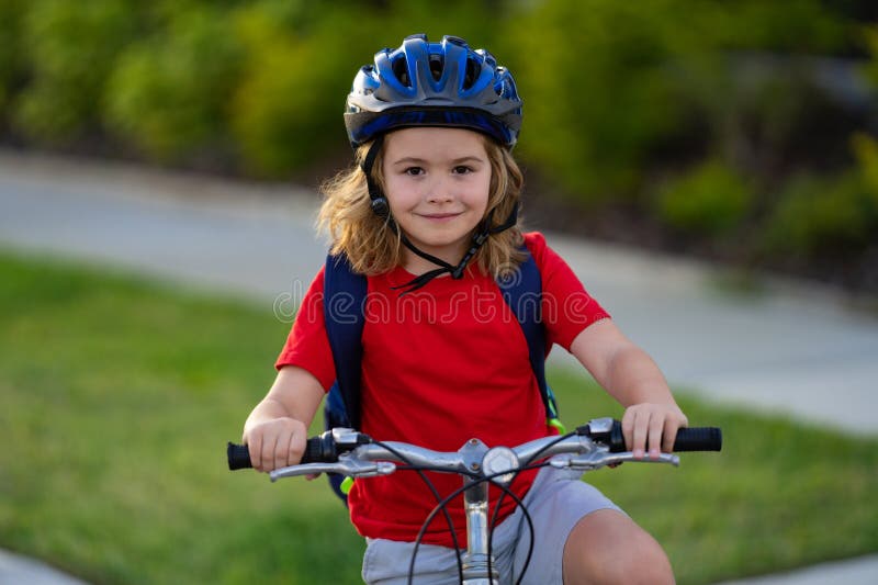 Little kid boy riding a bike in summer park. Child drive a bike on a driveway outside. Kid riding bikes in the city stock image