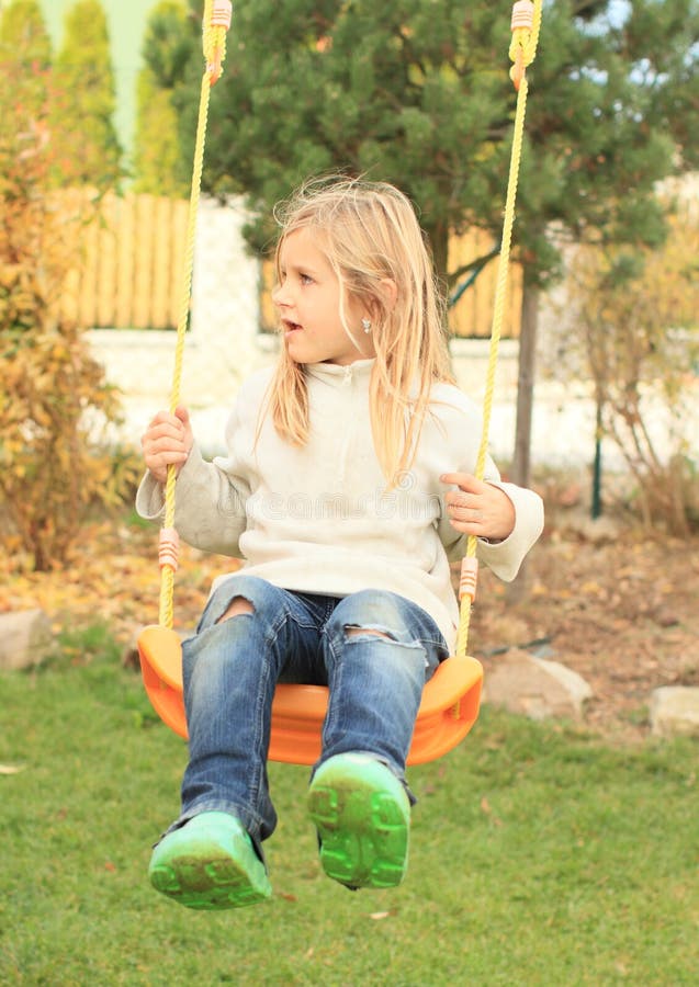 Little kid - disheveled girl on swing