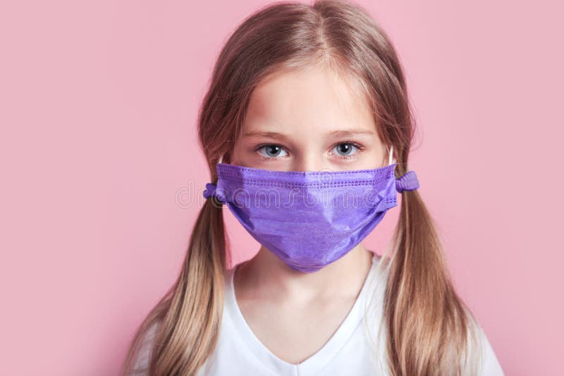 Little kid uses medical mask or surgical mask to protect her from virus, sickness, Covit-19 and coronavirus infection