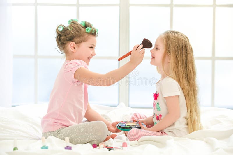 Little girl sisters. Маленькая девочка делает макияж. Девочки делают друг другу прически. Маленькая девочка в аудио терапии. Маленькая девочка с сережками.