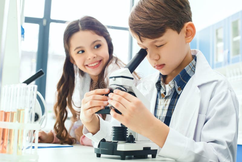 Little kids learning chemistry in school laboratory microscope experiment notes royalty free stock image