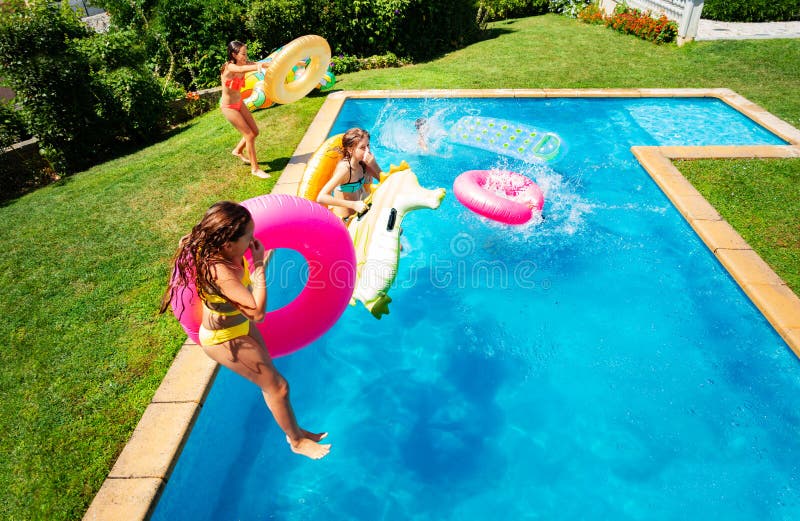 Little kids in mid air jump into pool water