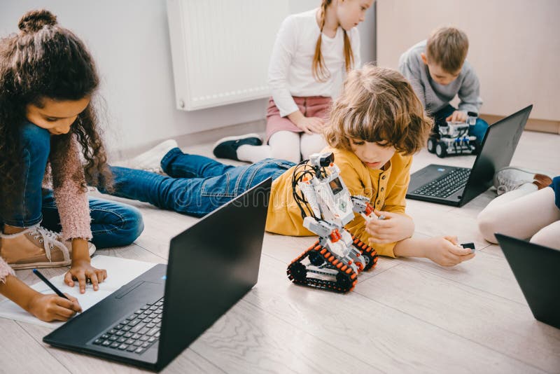 Little kids programming with laptops while sitting on floor, stem royalty free stock photography