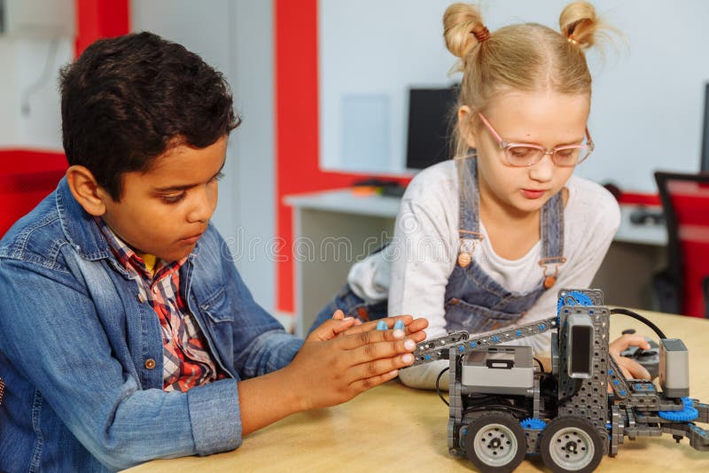 Mixed Racial group of School kids sitting at class with diy robot, stem education concept. stock photography