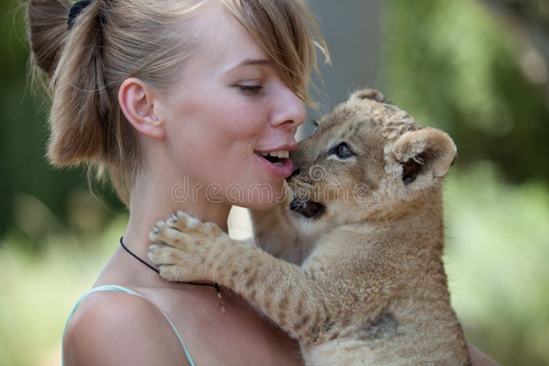 Little lion cub biting girl playing