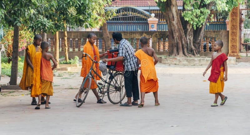 Little monks gathering around an ice cream man.