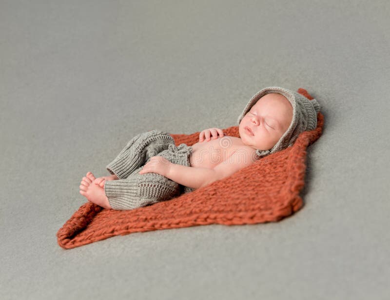 Little newborn baby sleeping on knitted blanket