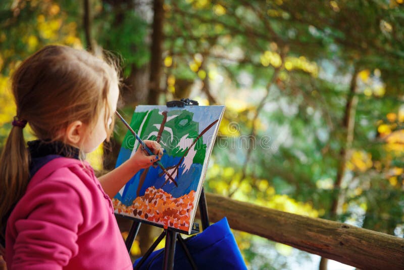 Little painter at work near waterfall