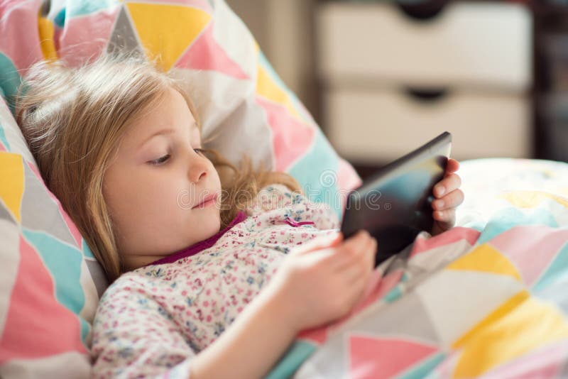 Little Girl Playing with Tablet in Bed Stock Photo - Image of holidays ...