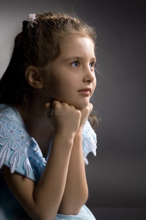 Little pretty thoughtful girl on the arm-chair