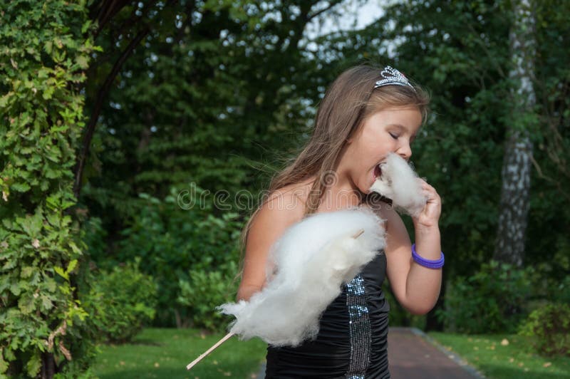 Little princess girl eating sweet cotton candy, portrait, summer day in the park stock image Little princess girl eating sweet cotton candy, portrait, summer day in the park stock image