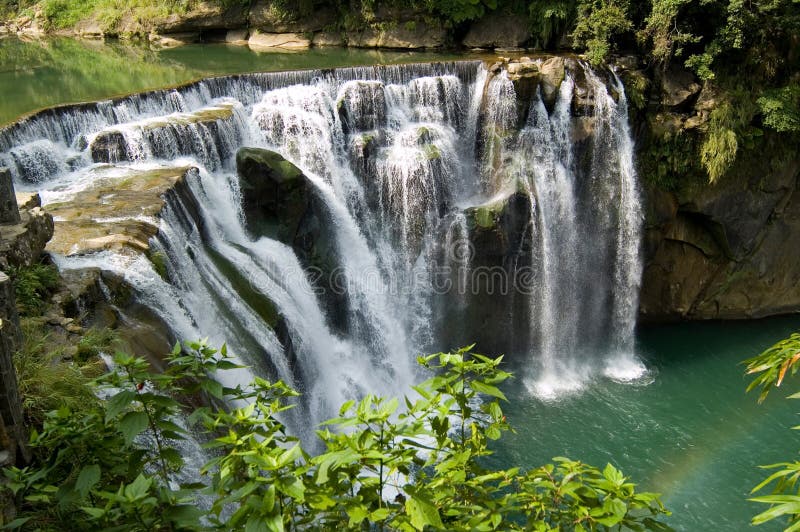 Little rainbow with waterfall stock photo