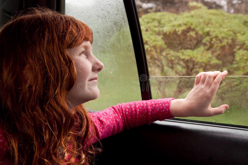Little red haired girl looking out car window on a rainy spring day royalty free stock image Little red haired girl looking out car window on a rainy spring day royalty free stock image