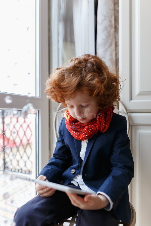 Little redhead boy uses a tablet PC royalty free stock images Little redhead boy uses a tablet PC royalty free stock images