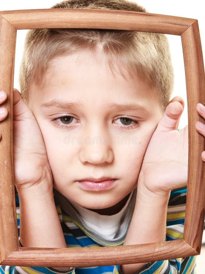 Little sad boy child framing his face