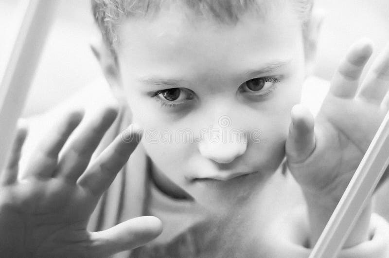Little sad boy looks out the window. Black and white photo of a close-up child. Hungry child with big clear eyes eating bread royalty free stock photo Little sad boy looks out the window. Black and white photo of a close-up child. Hungry child with big clear eyes eating bread royalty free stock photo