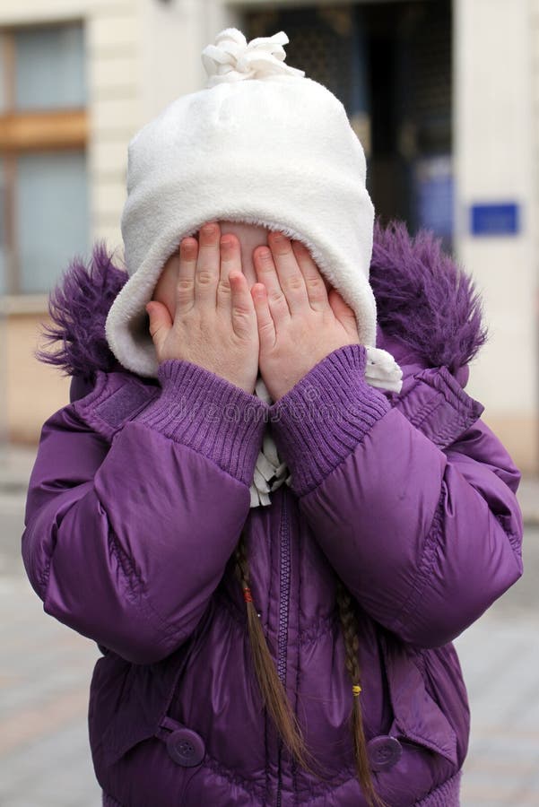 Little scared girl hiding face