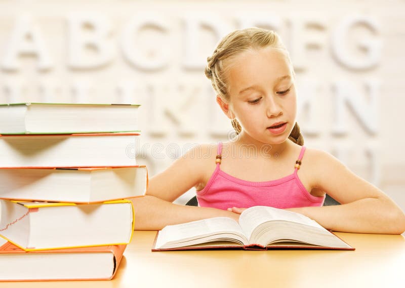 Little schoolgirl reading a book.