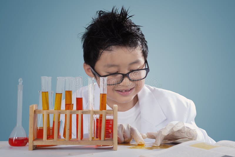 Picture of a little scientist doing experiments and touch liquid chemical with gloves on the table. Picture of a little scientist doing experiments and touch liquid chemical with gloves on the table