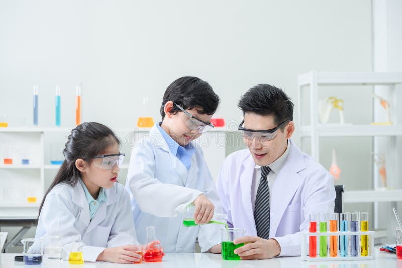 Little scientists adding color dye into beakers.