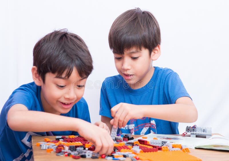 Little sibling boy playing plastic block indoor house education