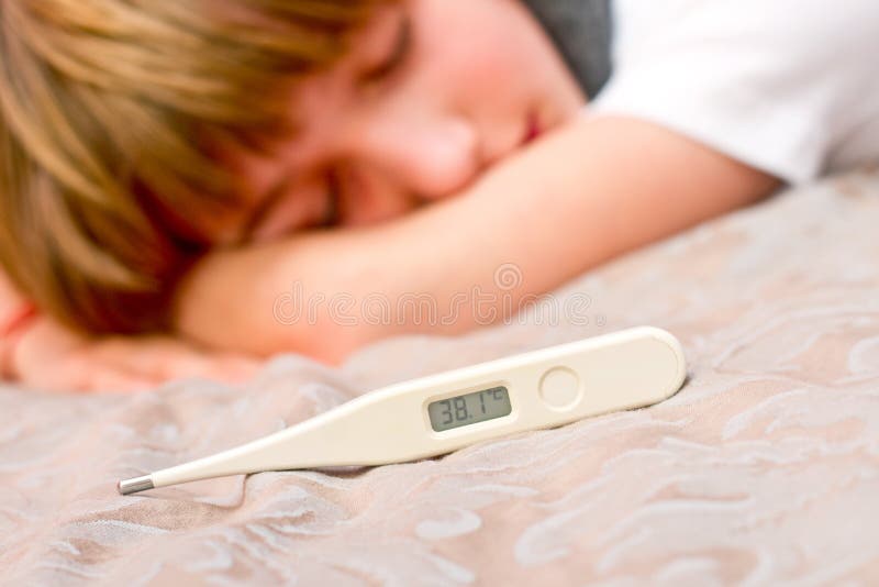 Little Sick Boy Lying on Bed with Digital Thermometer Stock Photo
