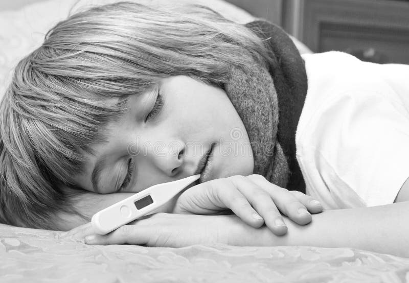 Little Sick Boy Lying on Bed with Digital Thermometer Stock Photo