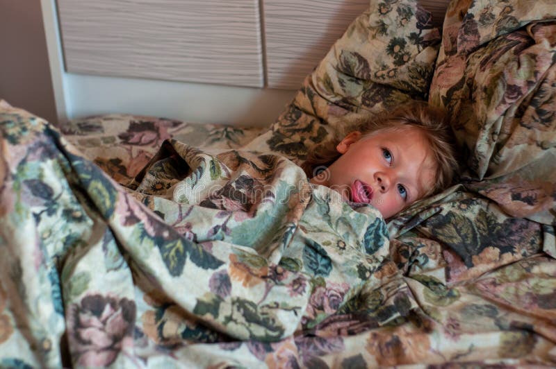A little sick girl in her bed royalty free stock images