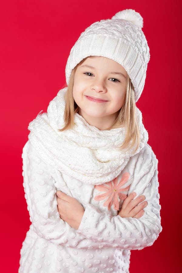 Little Smiling Blonde Girl in a White Hat and Scarf on Red Backg Stock ...