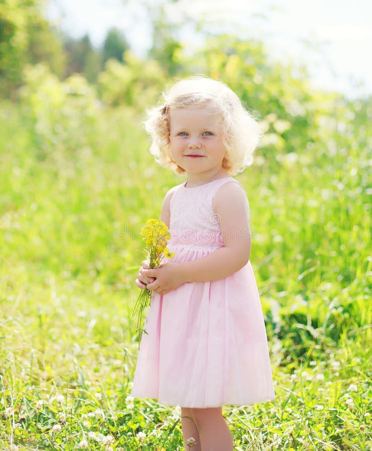 Little smiling girl child with flowers in spring