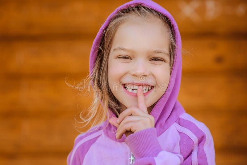 Little smiling girl in puts forefinger to lips royalty free stock photo Little smiling girl in puts forefinger to lips royalty free stock photo