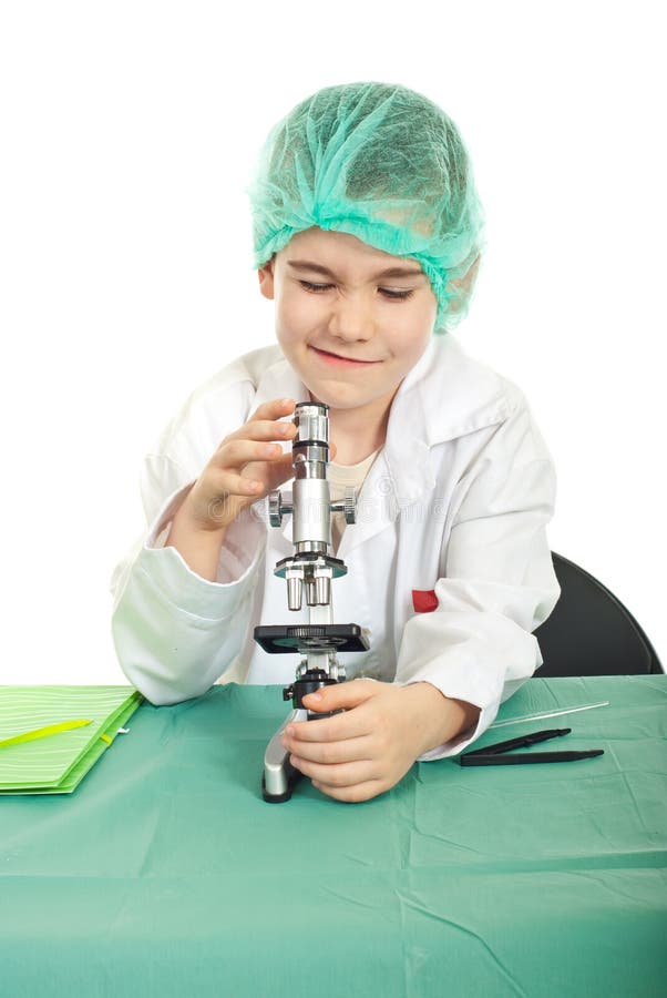 Little student boy using microscope