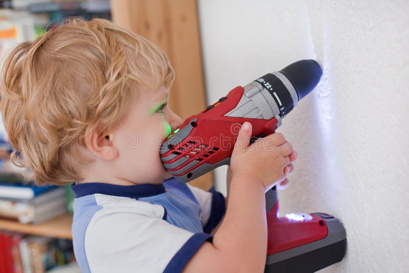 Little toddler boy playing with drill indoor stock photo Little toddler boy playing with drill indoor stock photo