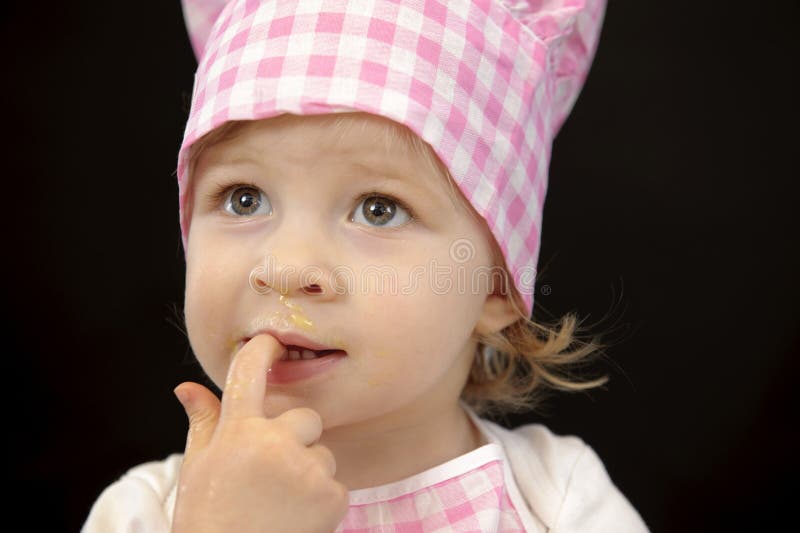 Little toddler cooking pastry in the kitchen,n