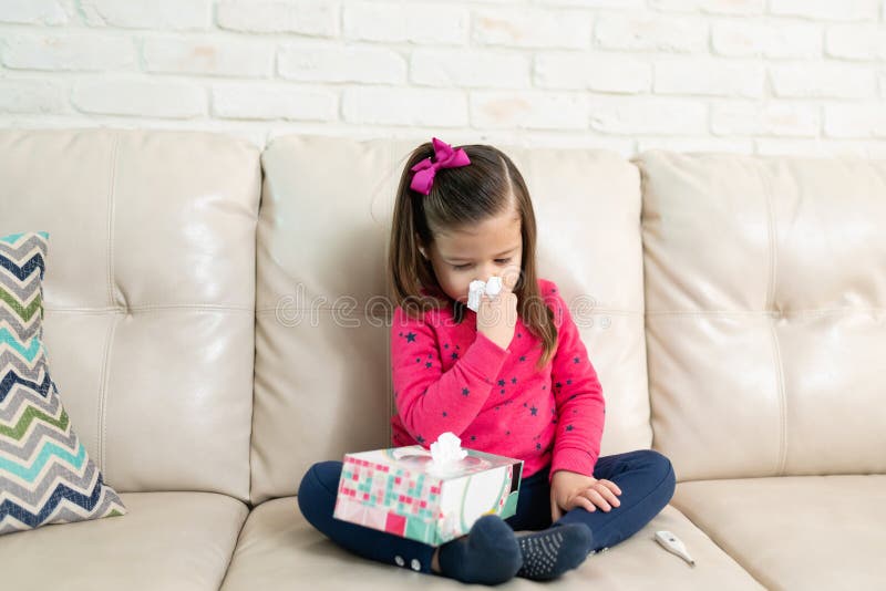 Pretty little girl blowing her nose at home royalty free stock photography Pretty little girl blowing her nose at home royalty free stock photography