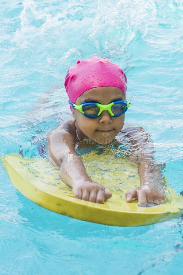 Little Young Girl Learning Swimming in Blue Water of the Swimming Pool. Little Young Girl Learning Swimming in Blue Water of the Swimming Pool