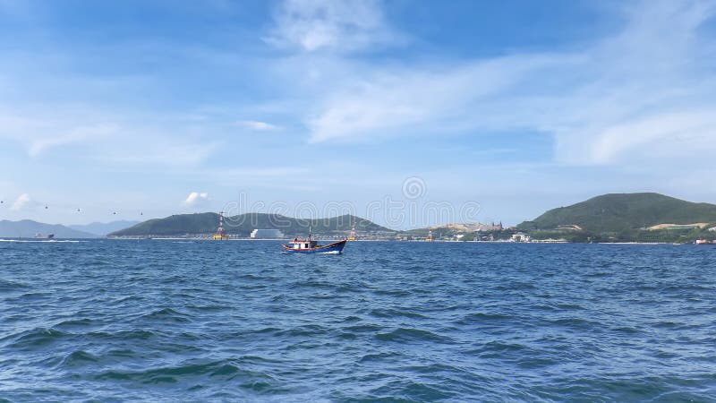 Littoral d'île de Vinperl, mer de sud de la Chine, collines, lumière du soleil, un petit bateau à l'arrière-plan photos stock