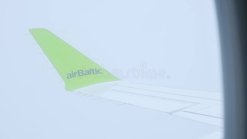 Lituanie 18 juin 2023 Aile d'avion en nuages. Société du logo AirBaltic. Vue sur un avion de passagers volant à travers banque de vidéos