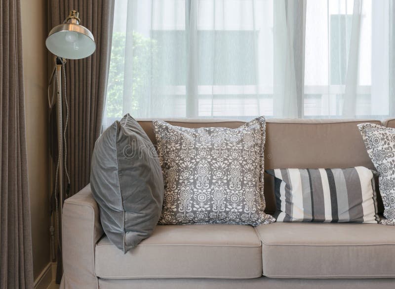Living Room with Brown Sofa and Grey Patterned Pillows at Home Stock