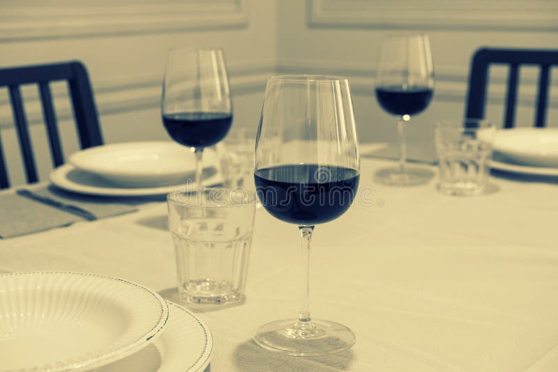 Living Room with Dining Table with Silverware and Red Wine Glasses in a Modern and Bright