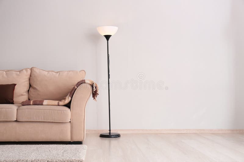 Living Room with Sofa and Floor Lamp Near Light Wall Stock Image