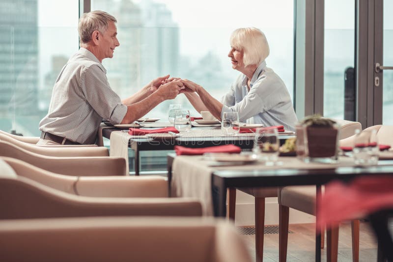 Livliga pensionerade par som har lunch i en restaurang royaltyfri bild Livliga pensionerade par som har lunch i en restaurang royaltyfri bild