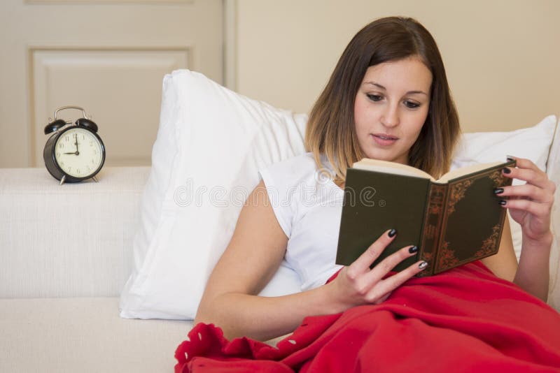Livre de lecture de lit de femme photo stock Livre de lecture de lit de femme photo stock