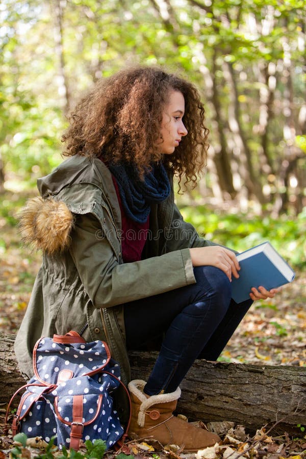 Livre de lecture de l'adolescence de fille en parc d'automne photographie stock libre de droits Livre de lecture de l'adolescence de fille en parc d'automne photographie stock libre de droits
