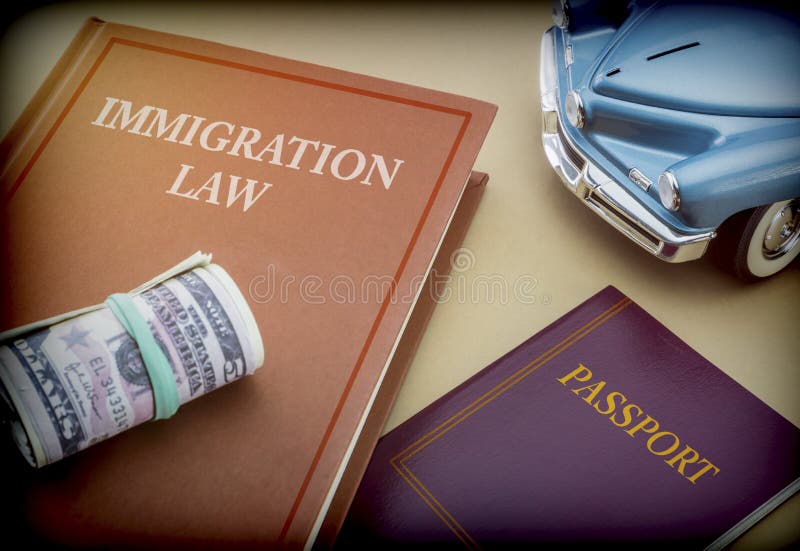 Livre de loi d'immigration à côté d'un passeport et d'un véhicule miniature bleu images libres de droits Livre de loi d'immigration à côté d'un passeport et d'un véhicule miniature bleu images libres de droits