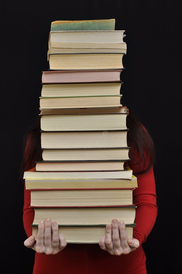 Lady in red holding a heavy stack of books in hands. Lady in red holding a heavy stack of books in hands